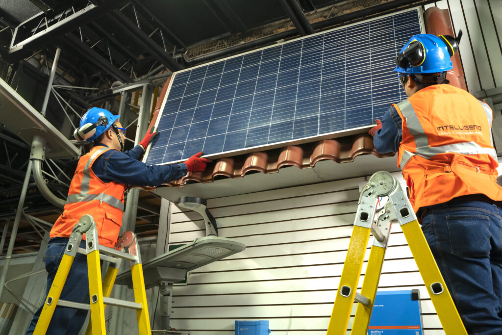 Técnicos de INTELLIGENIO montando un módulo fotovoltaico sobre techo